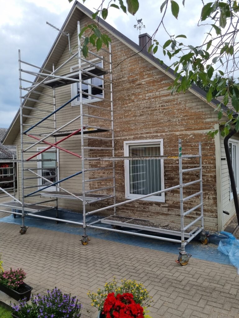 Medinės sienos dalis jau nuskusta senų dažų