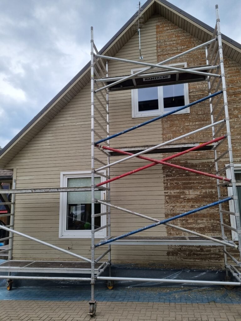 Pusė medinio fasado nuvalyta nuo senų dažų