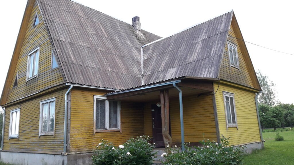 Pablukęs ir neapsaugotas medinis namo fasadas prieš renovaciją