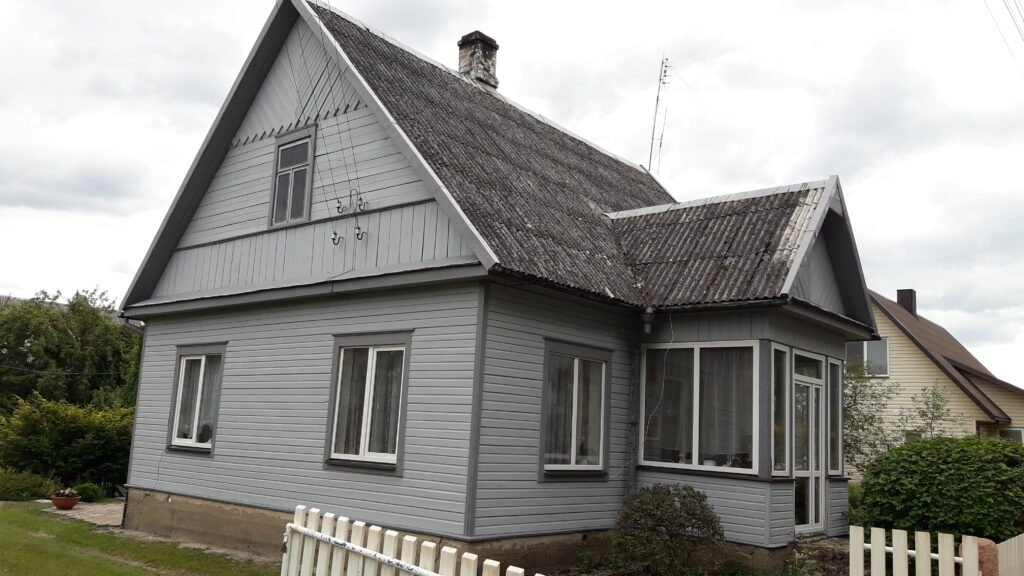 Vienodai nudažytas medinio namo fasadas