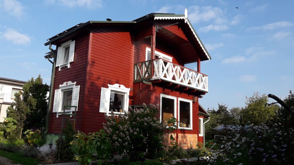 Medinio namo fasadas po dažymo Anykščių rajone – švarus paviršius ir lygus tonas