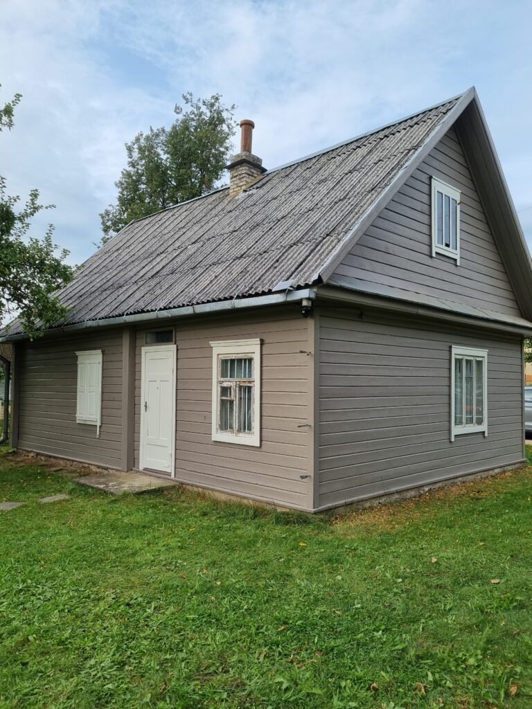 Medinio namo fasadas po dažymo – stabilus vaizdas atviroje vietovėje