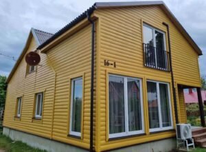 Naujai perdažytas medinio namo fasadas po paruošimo darbų - estetiška apdaila