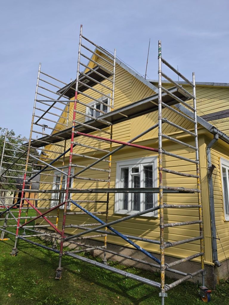 Nudažytas medinis namas su dar nenuimtais pastoliais